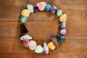 Circle of colorful pebbles stones on wooden table